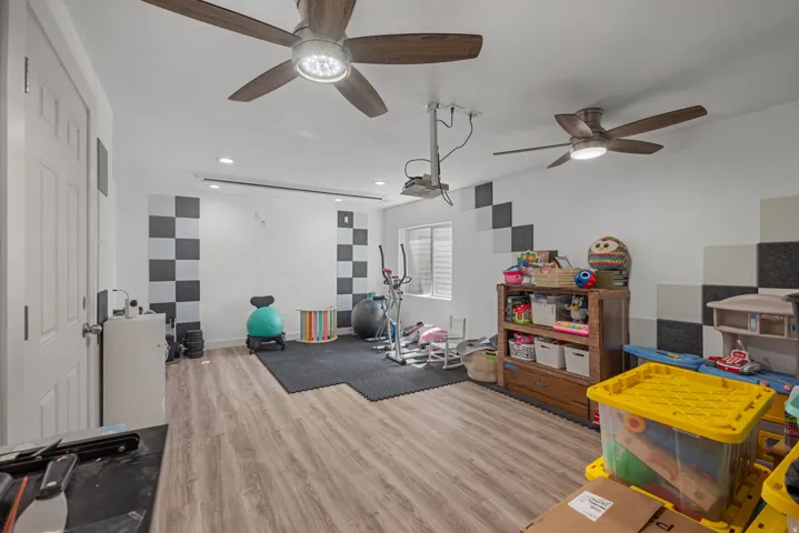 Wood-finish flooring, recessed lighting, and dual ceiling fans with integrated lighting