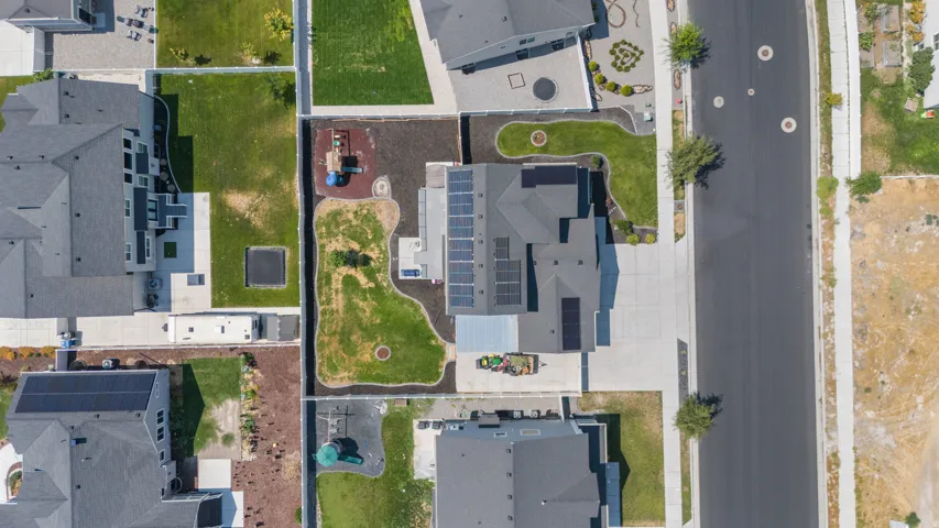 Manicured lawn, mature landscaping, and an extensive concrete driveway