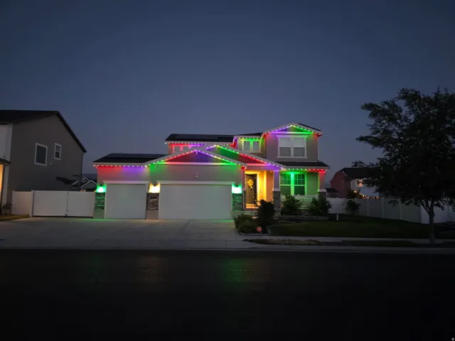 Two-story residence featuring a two-car garage, solar panels, and a front porch