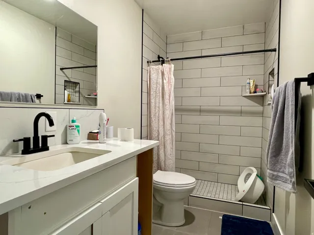 White shaker-style vanity with a composite countertop and integrated sink