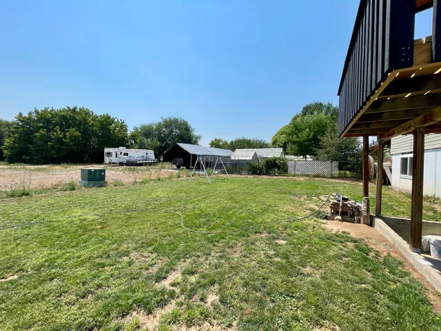 Expansive grassy area with a partial privacy fence