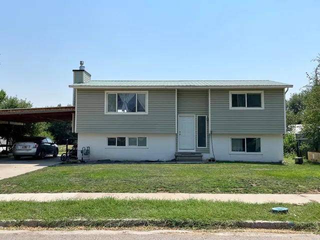 Two-story residence with light green siding and a metal roof