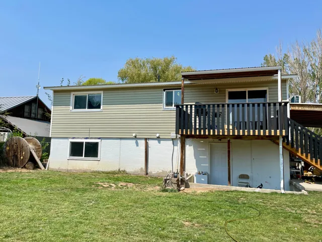 Exterior siding with multiple windows, covered deck, and exterior staircase