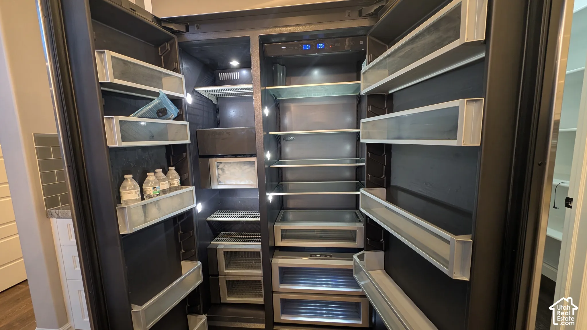 Integrated side-by-side refrigerator with interior LED lighting, multiple door shelves, and glass shelving