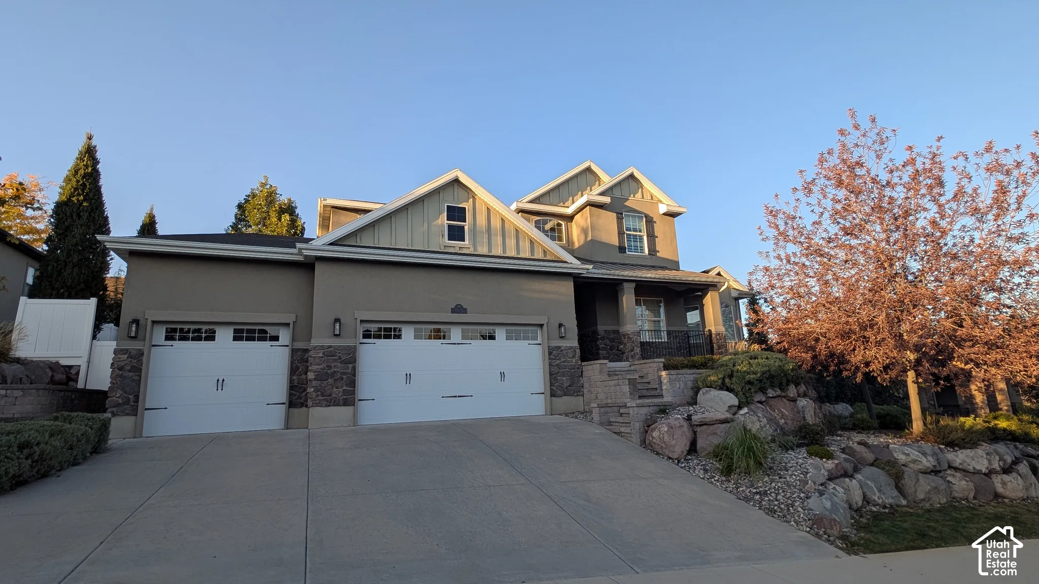 Multi-level residence featuring a stucco exterior and stone accents