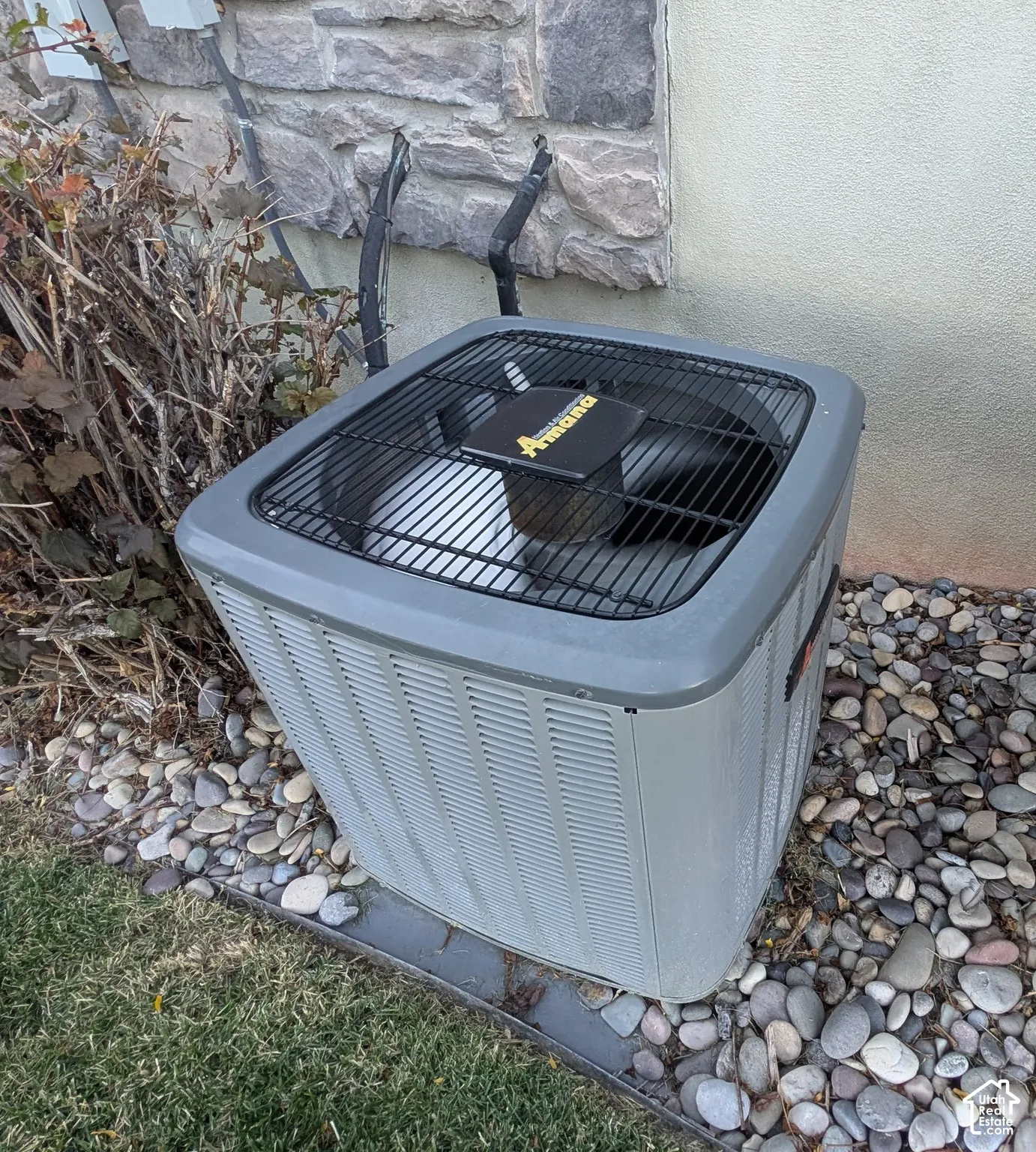 Amana brand HVAC unit with stone and stucco exterior elements