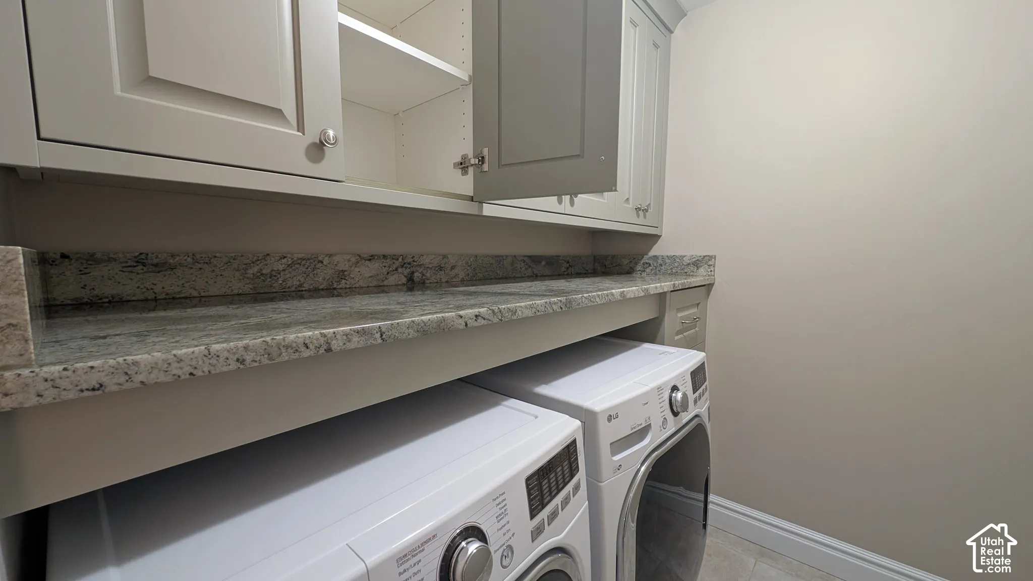 Built-in cabinetry with paneled doors, granite countertop, and tile flooring