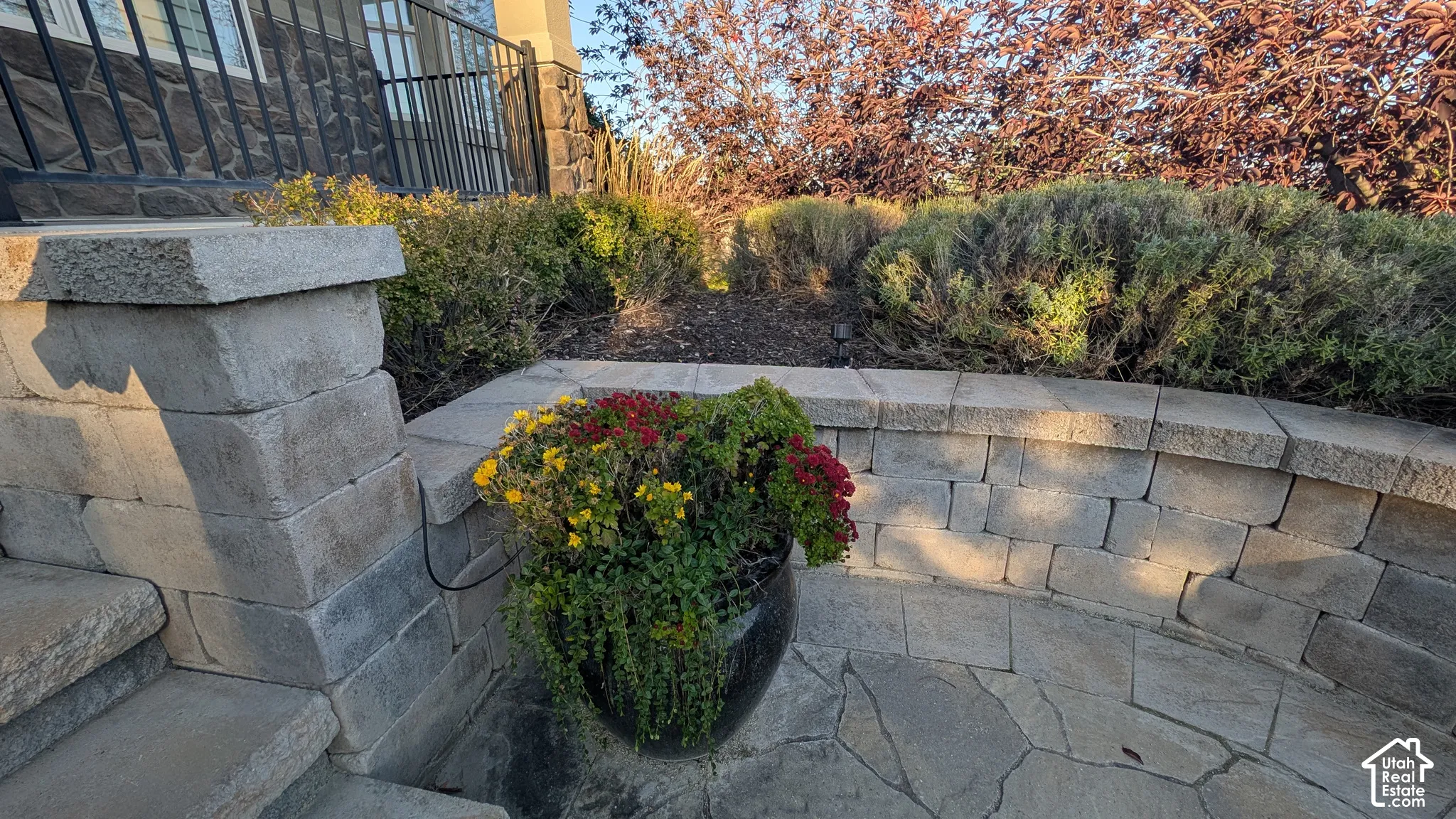 Stone-block retaining wall with integrated landscaping and flagstone paving