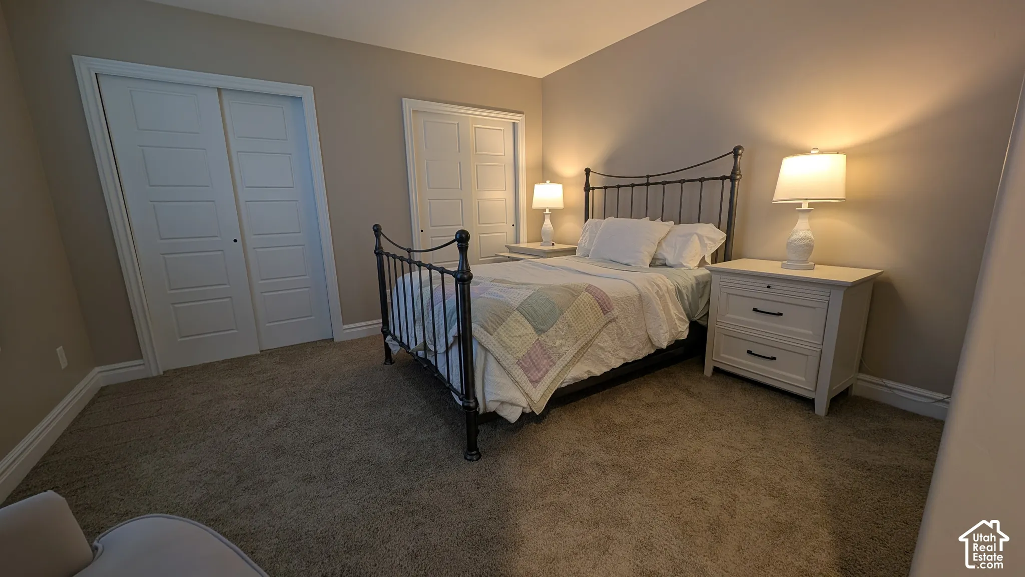 Charming spacious bedroom sharing jack and jill bathroom. Soft carpeted flooring, neutral wall paint, white trim, and two paneled closet doors