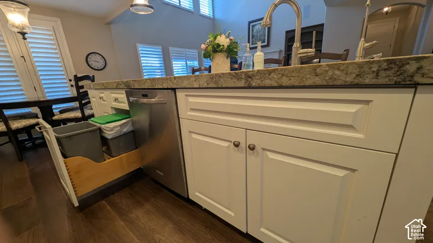 White shaker-style cabinetry with dark hardware, hidden garbage containers
