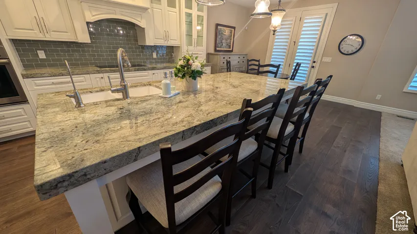 Kitchen island with an undermount sink, a gooseneck faucet, and a stone countertop