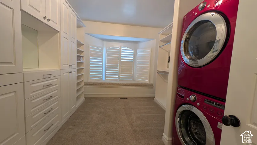 Convenient Washer-dryer stackable in Huge Master walk in closet. Built-in cabinetry with drawer storage, recessed lighting, and a window bench with plantation shutters