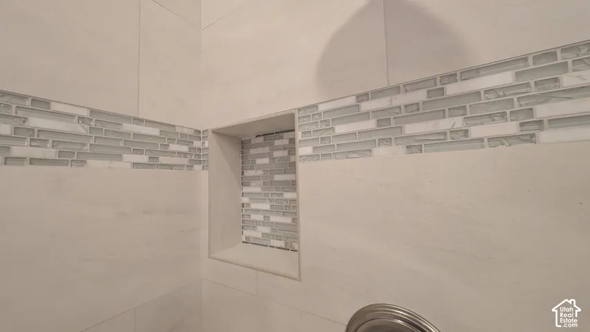 Master bath Tiled shower enclosure featuring light-toned large format tiles, a decorative glass and stone mosaic accent band, and a recessed niche with mosaic tiling