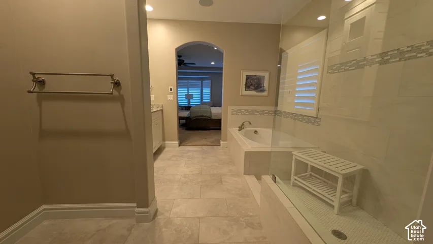 Recessed lighting, tile flooring, built-in bathtub, glass-enclosed shower, and plantation shutters in Master bath