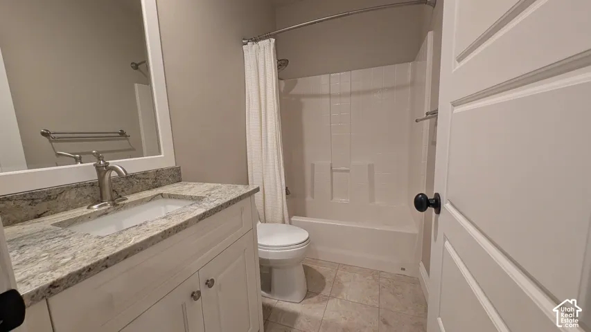 Bathroom featuring a white vanity with a granite-style countertop, undermount sink, and a framed mirror