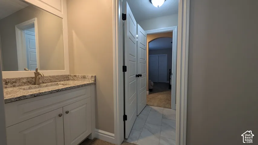 Large Jack and Jill bathroom  with White vanity with a stone countertop and an undermount sink