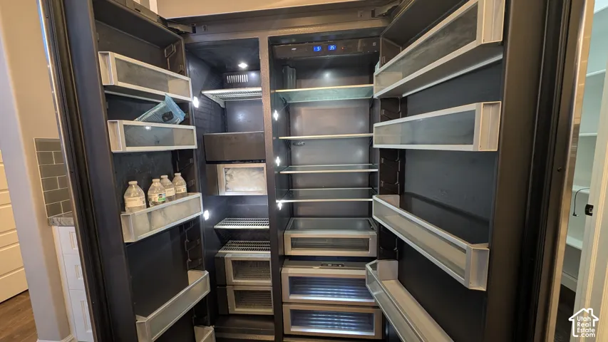Integrated Jennair side-by-side refrigerator with interior LED lighting, multiple door shelves, and glass shelving