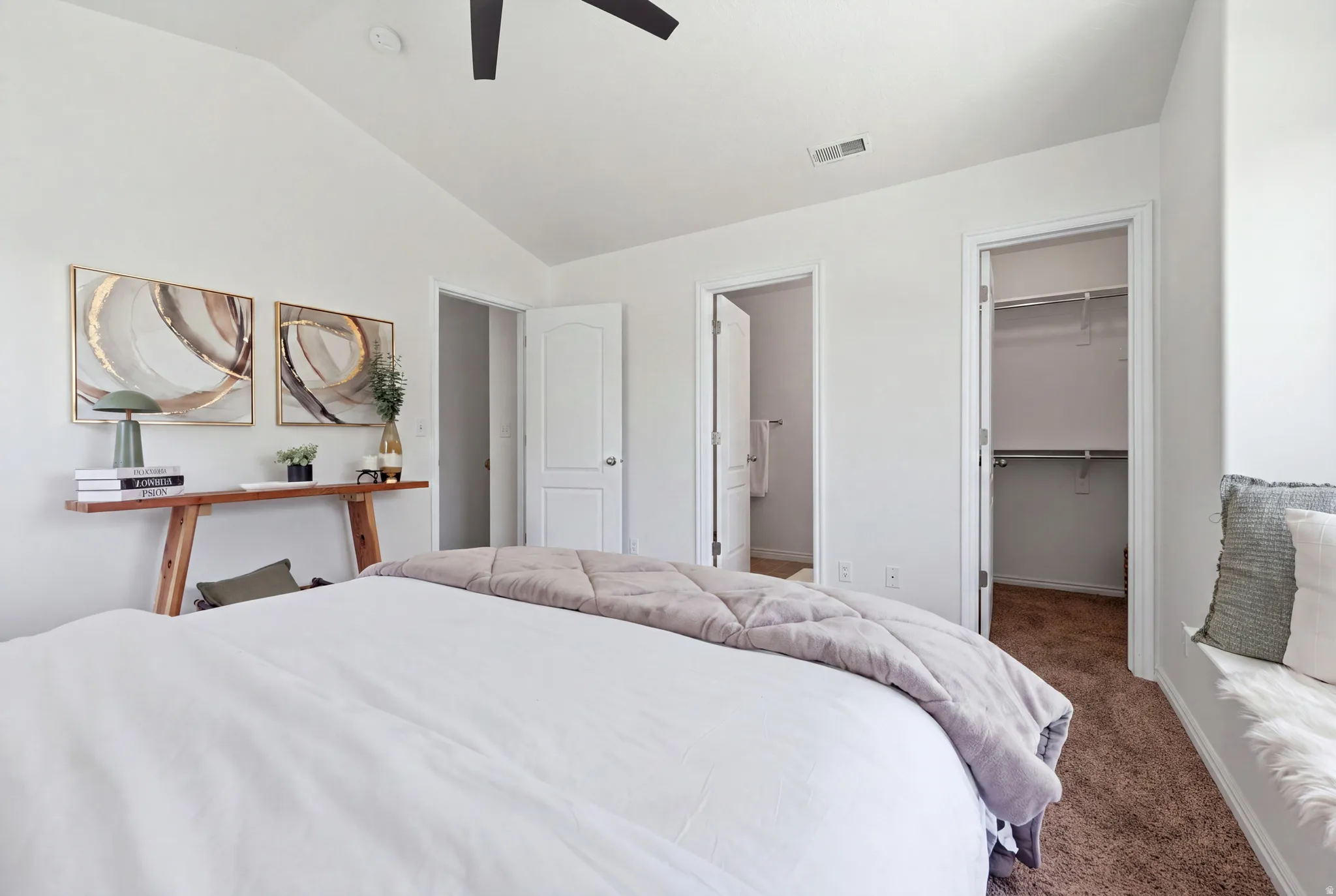 Vaulted ceiling with a ceiling fan, carpeted flooring, built-in closet, and a window seat