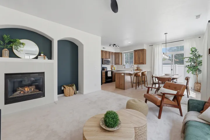 Gas fireplace with a tile surround, arched wall niches, wood cabinetry, built-in kitchen island, and a sliding glass door