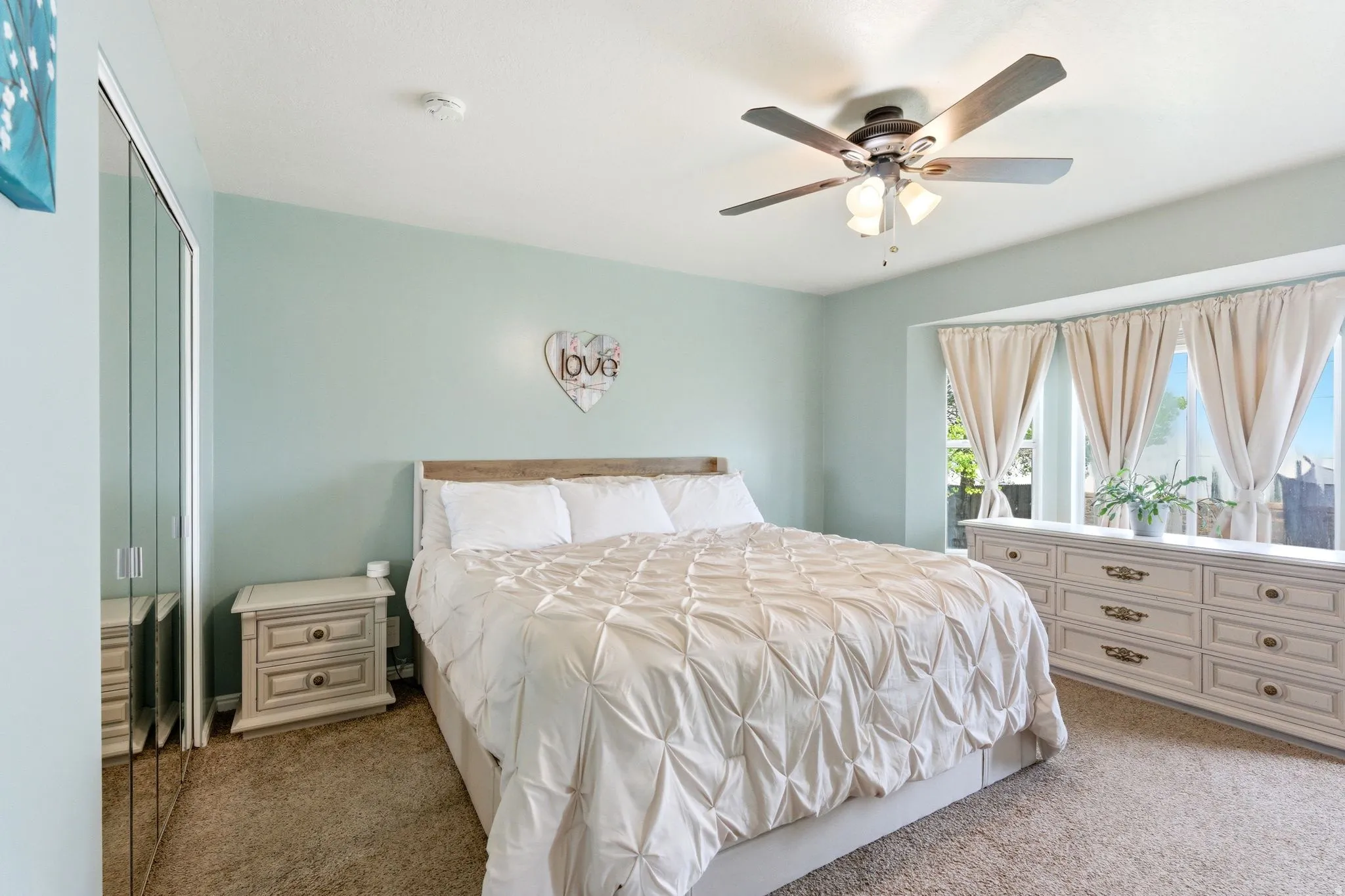 Recessed bay windows, ceiling fan, and carpeted flooring