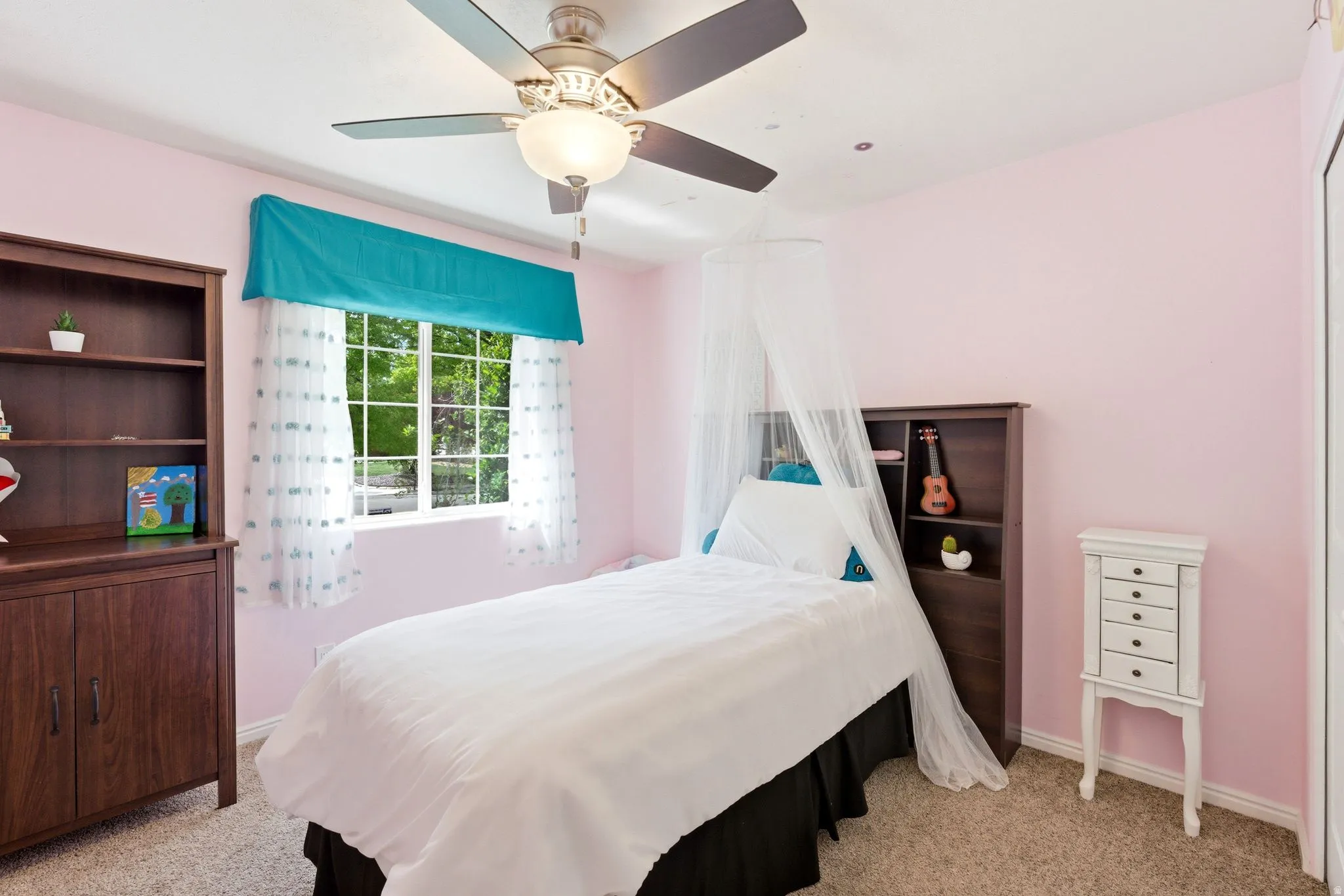 Built-in ceiling fan with integrated lighting, window with exterior landscaping, and neutral carpeting
