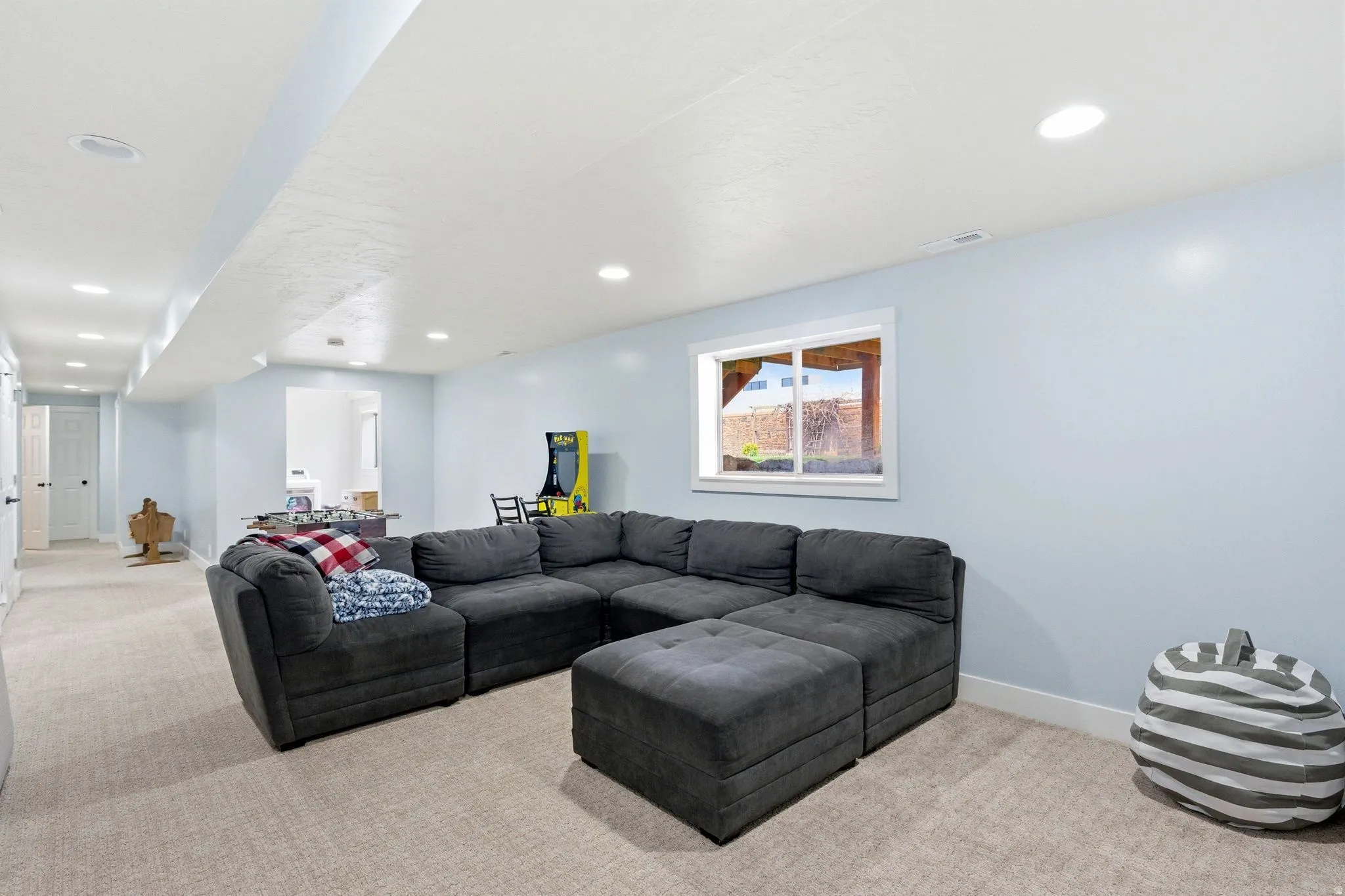 Recessed lighting, light-colored walls, and neutral carpeting create an inviting atmosphere