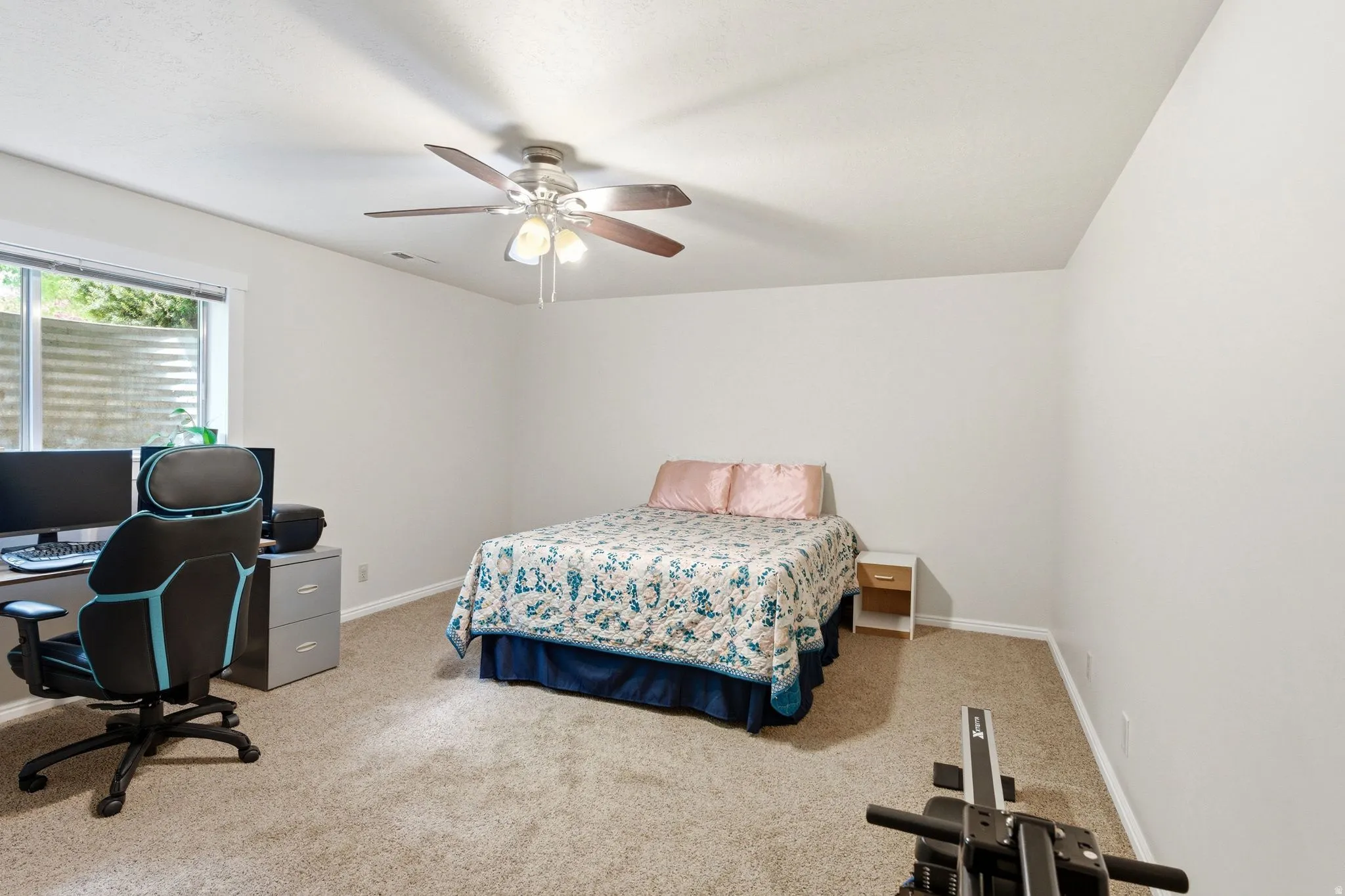 Carpeted room featuring a window with horizontal blinds, a ceiling fan with integrated lighting, and white painted walls