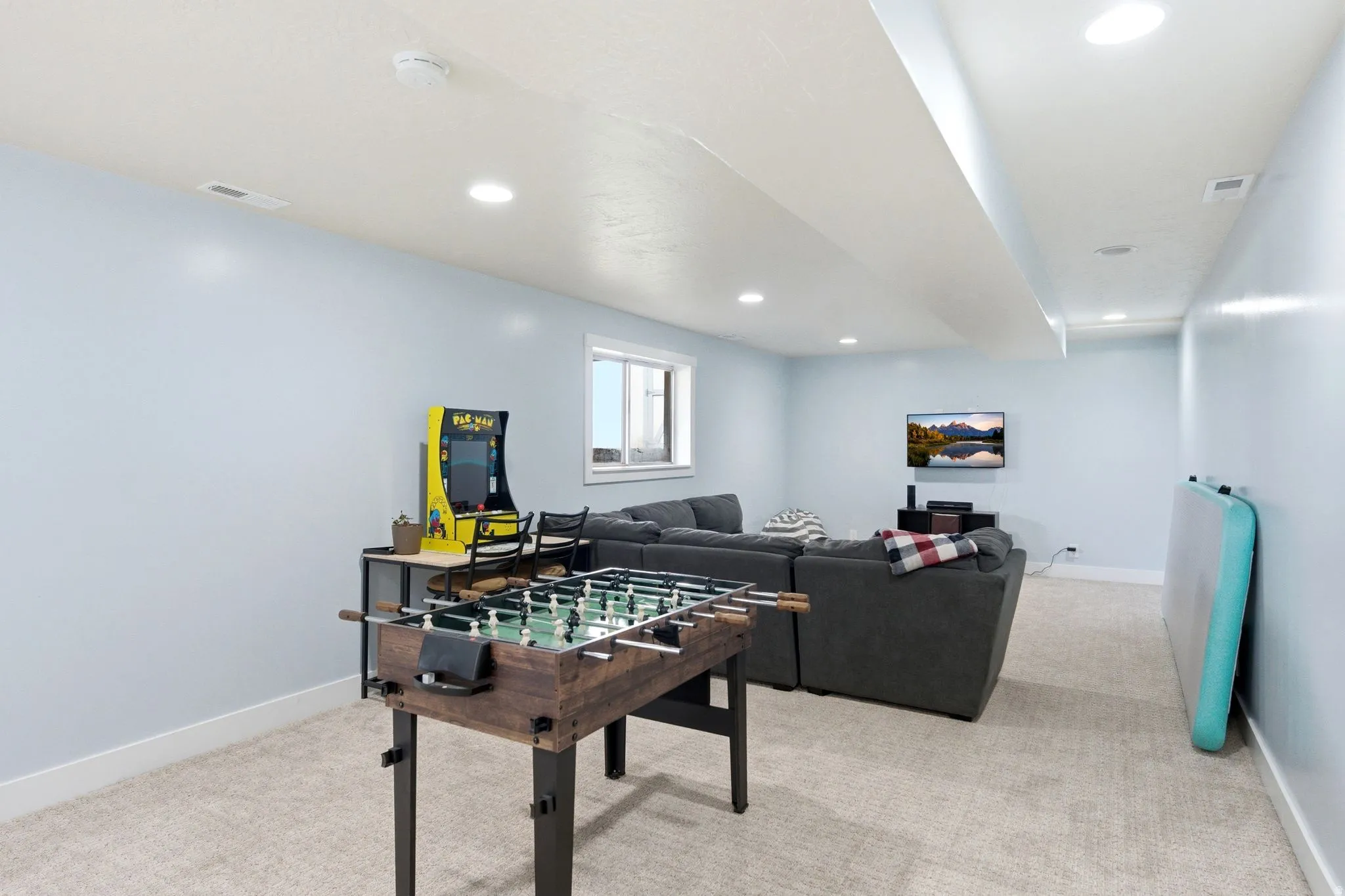 Recessed lighting, light-toned walls, and neutral carpeting