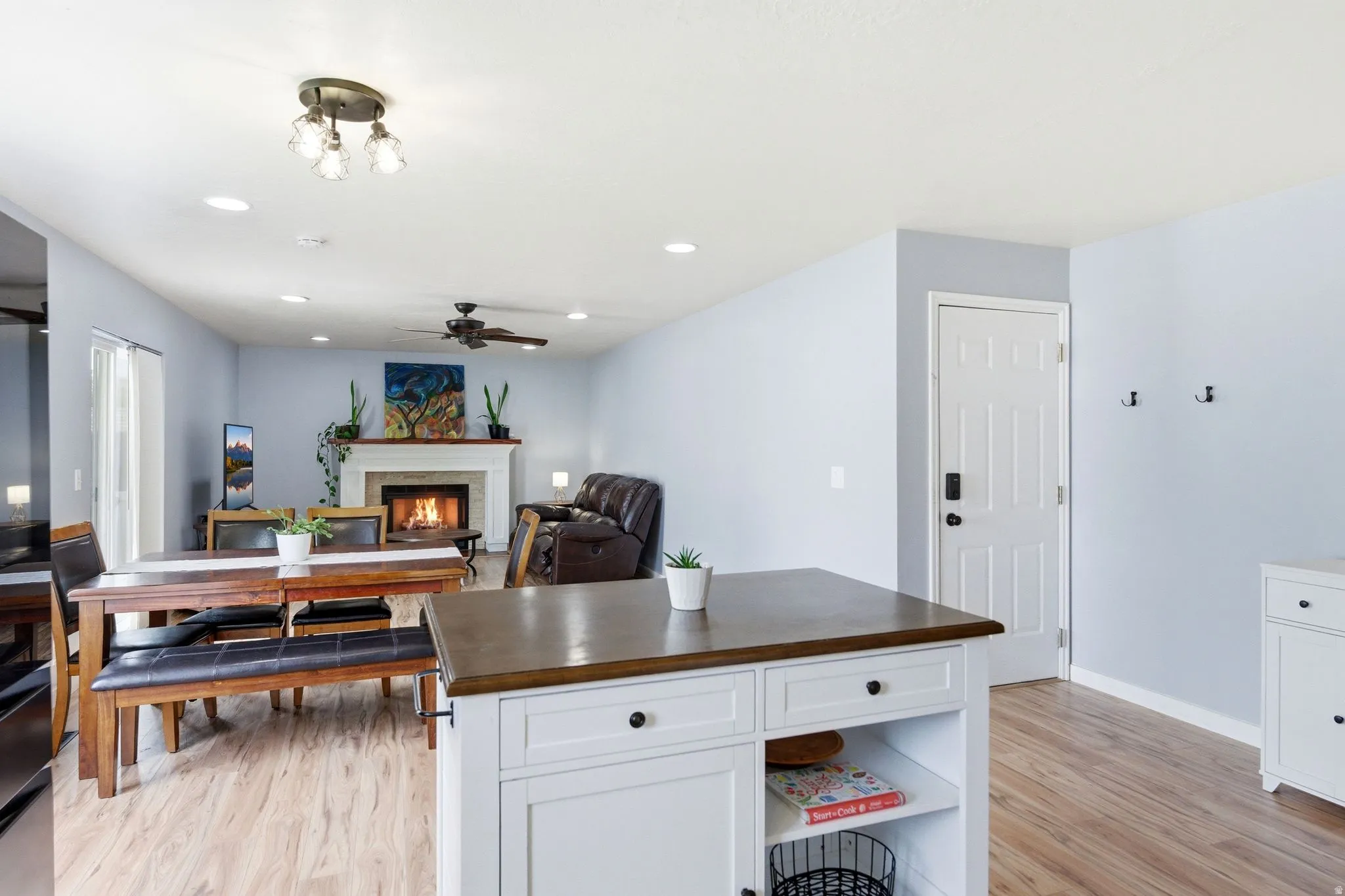 Wood-finish flooring throughout, white baseboards, and light blue wall paint