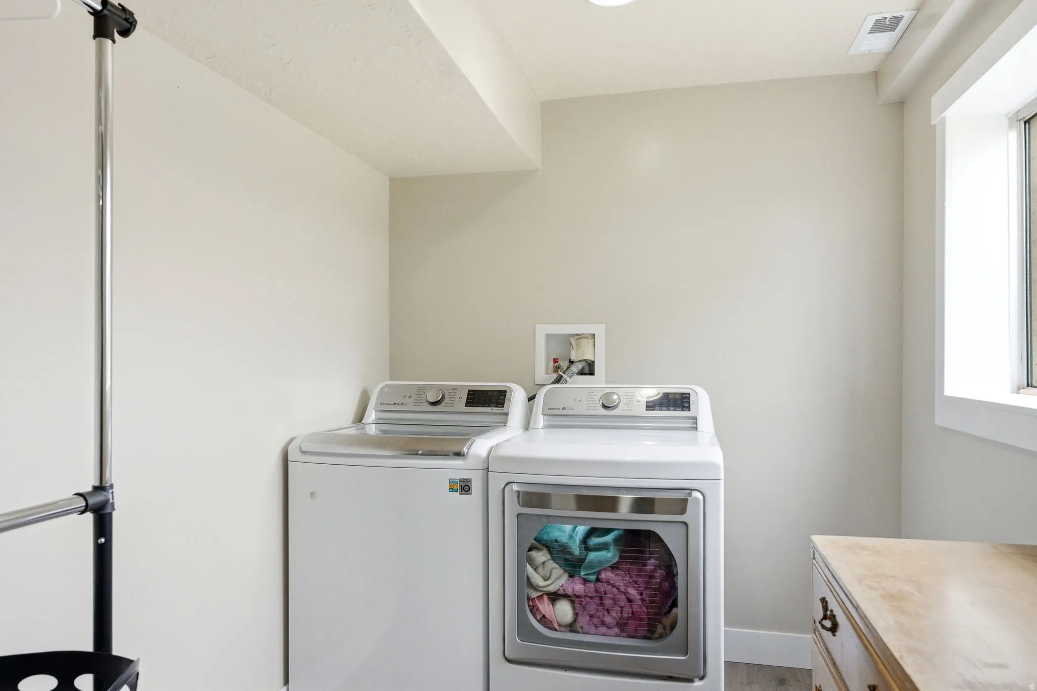 Laundry area with neutral wall color, recessed ceiling lighting, and a window