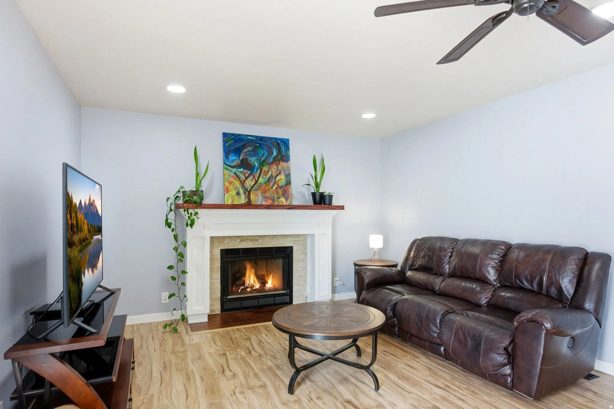 Fireplace with a white mantel, recessed lighting, wood-finish flooring, and a ceiling fan