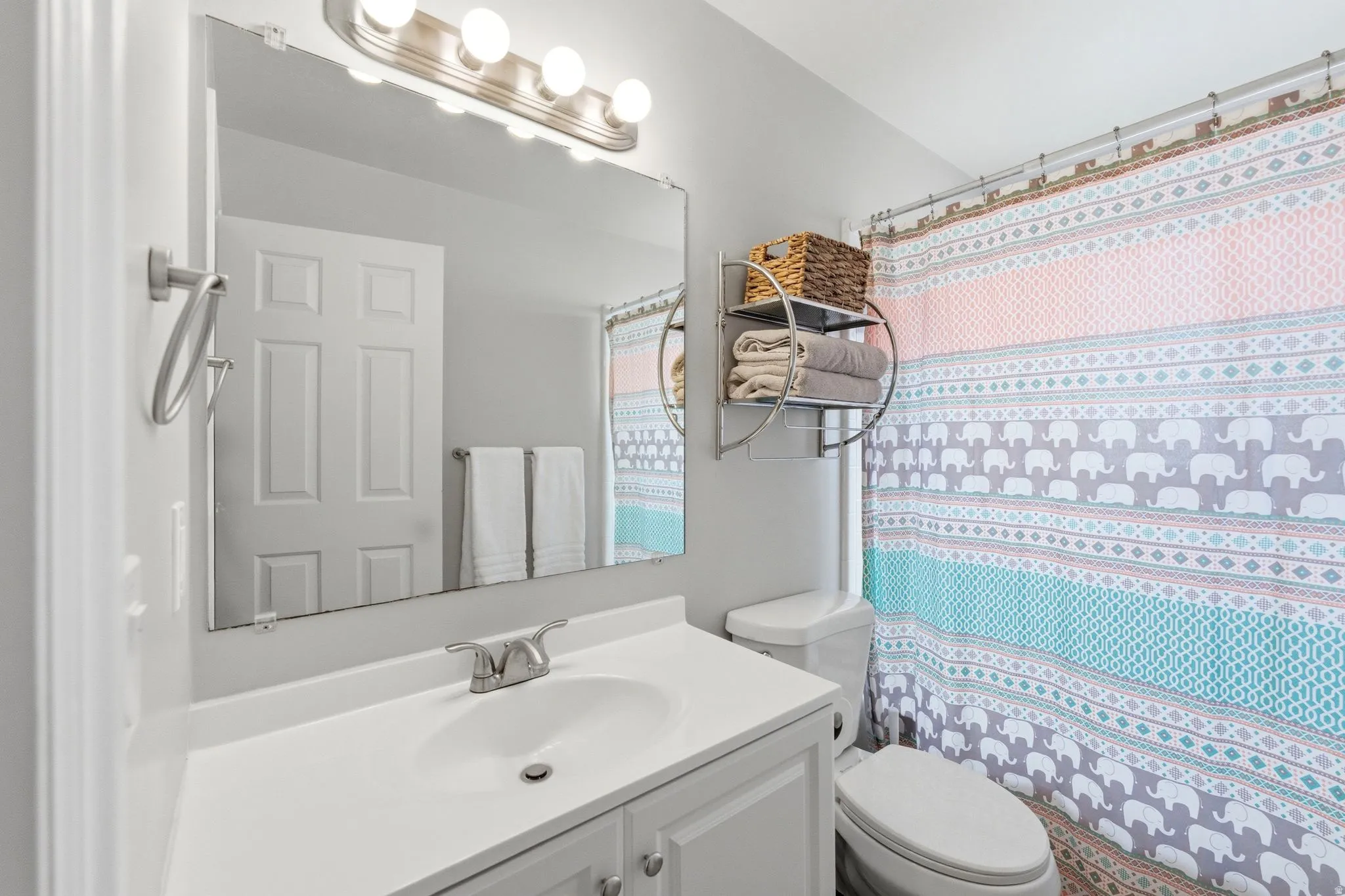 Vanity with an integrated sink, polished chrome faucet, and storage cabinetry