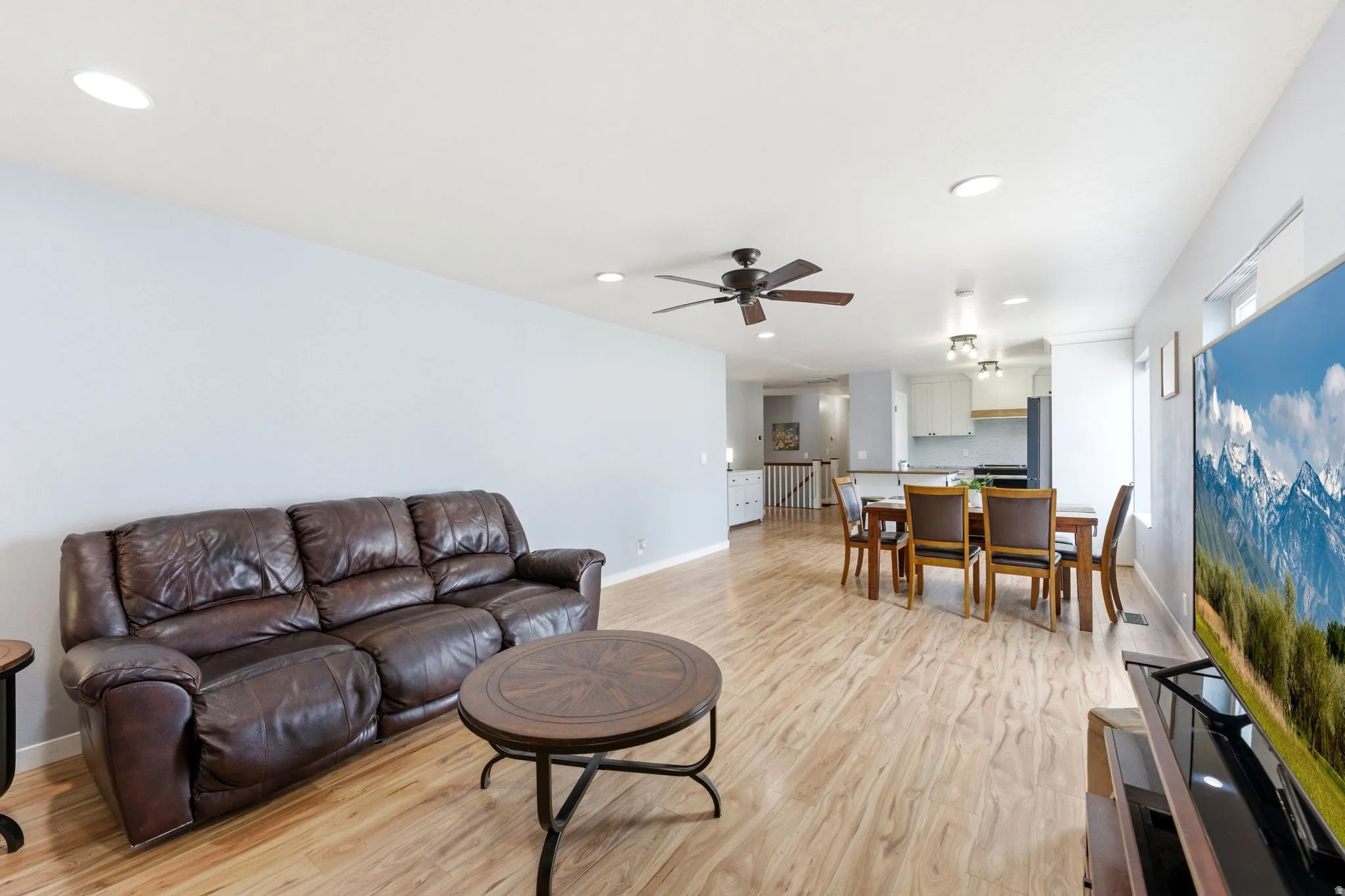 Open concept design with wood-finish flooring, recessed lighting, and a dining area with a multi-light fixture