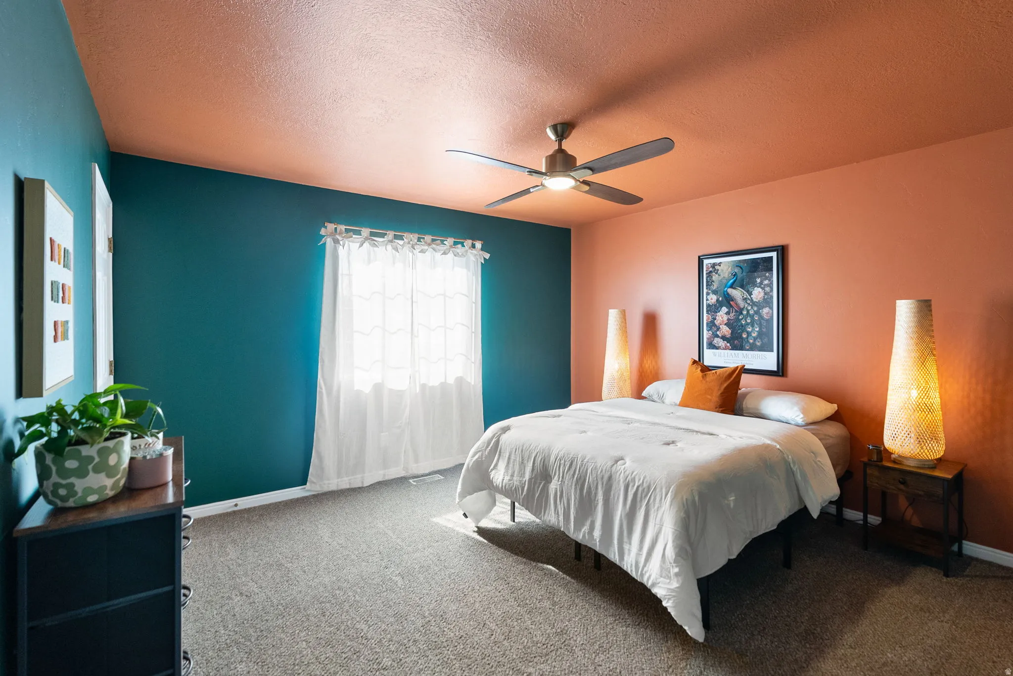 Neutral carpeting with a window featuring white curtains