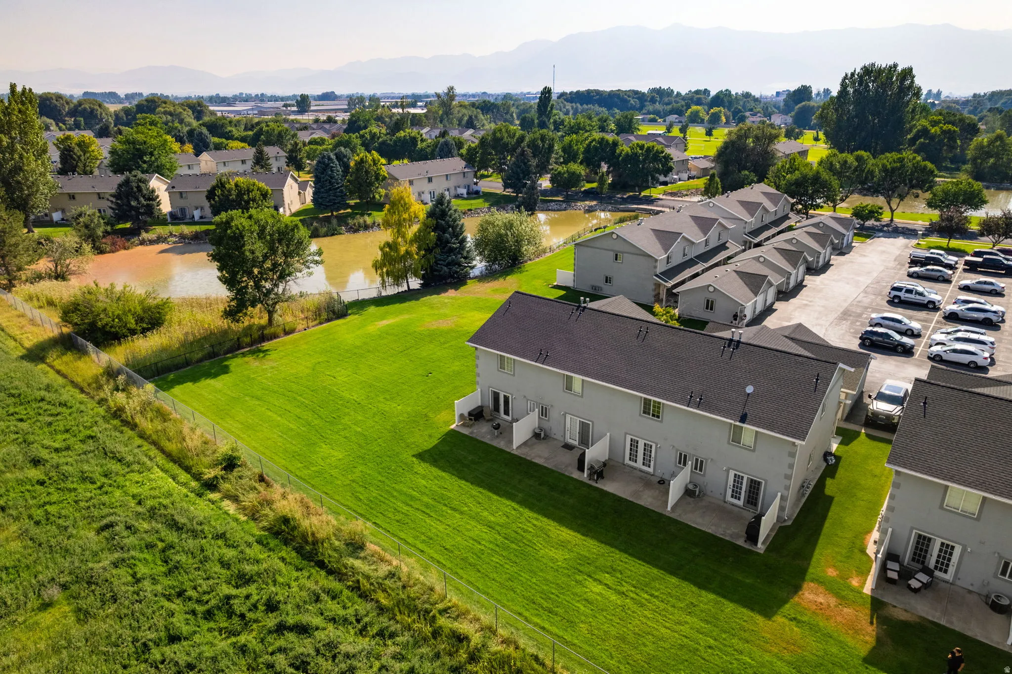 Townhome community with private patios, expansive green spaces, and a shared parking area