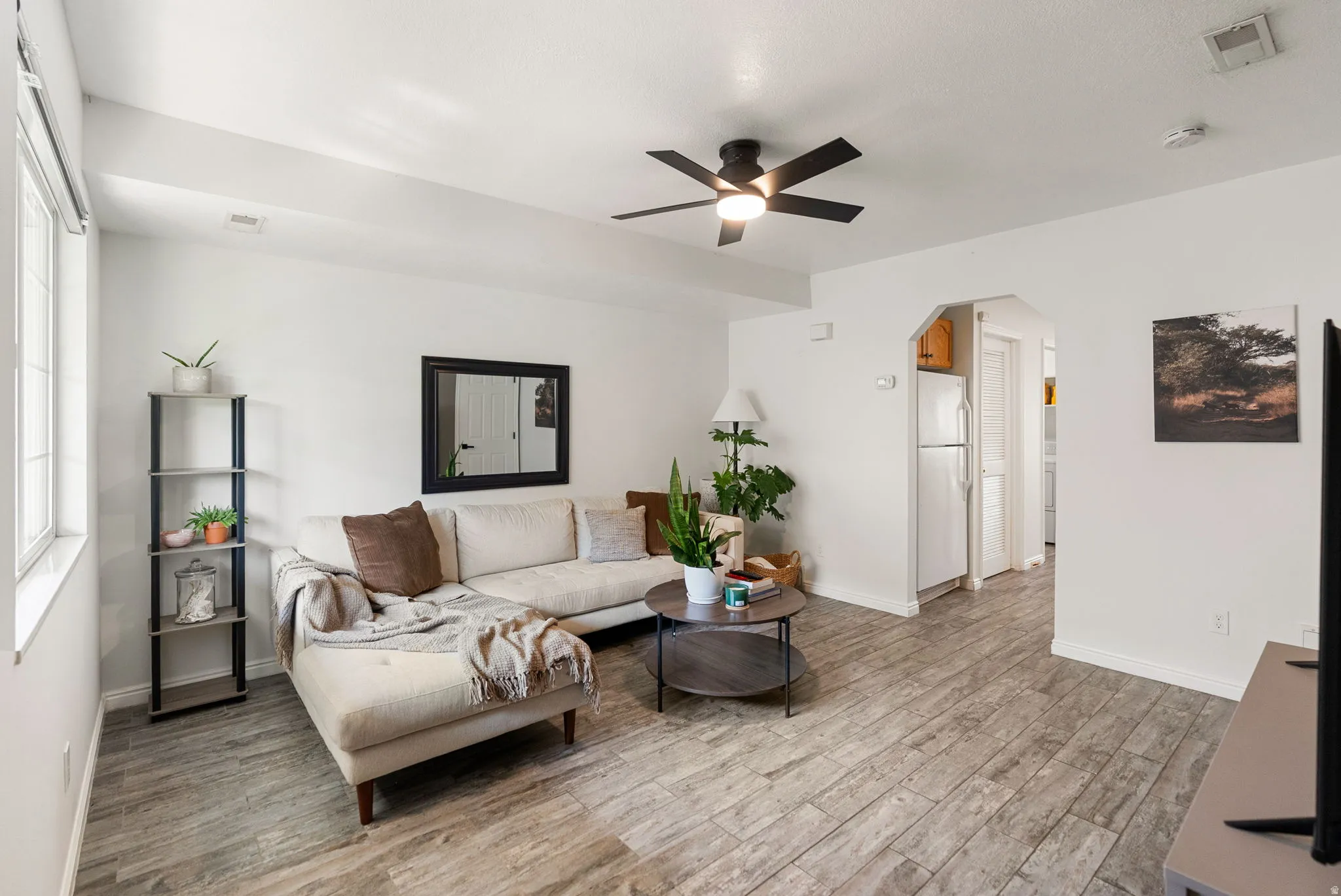 Bright interior with wood-finish tile flooring, white walls, and a contemporary ceiling fan with integrated lighting