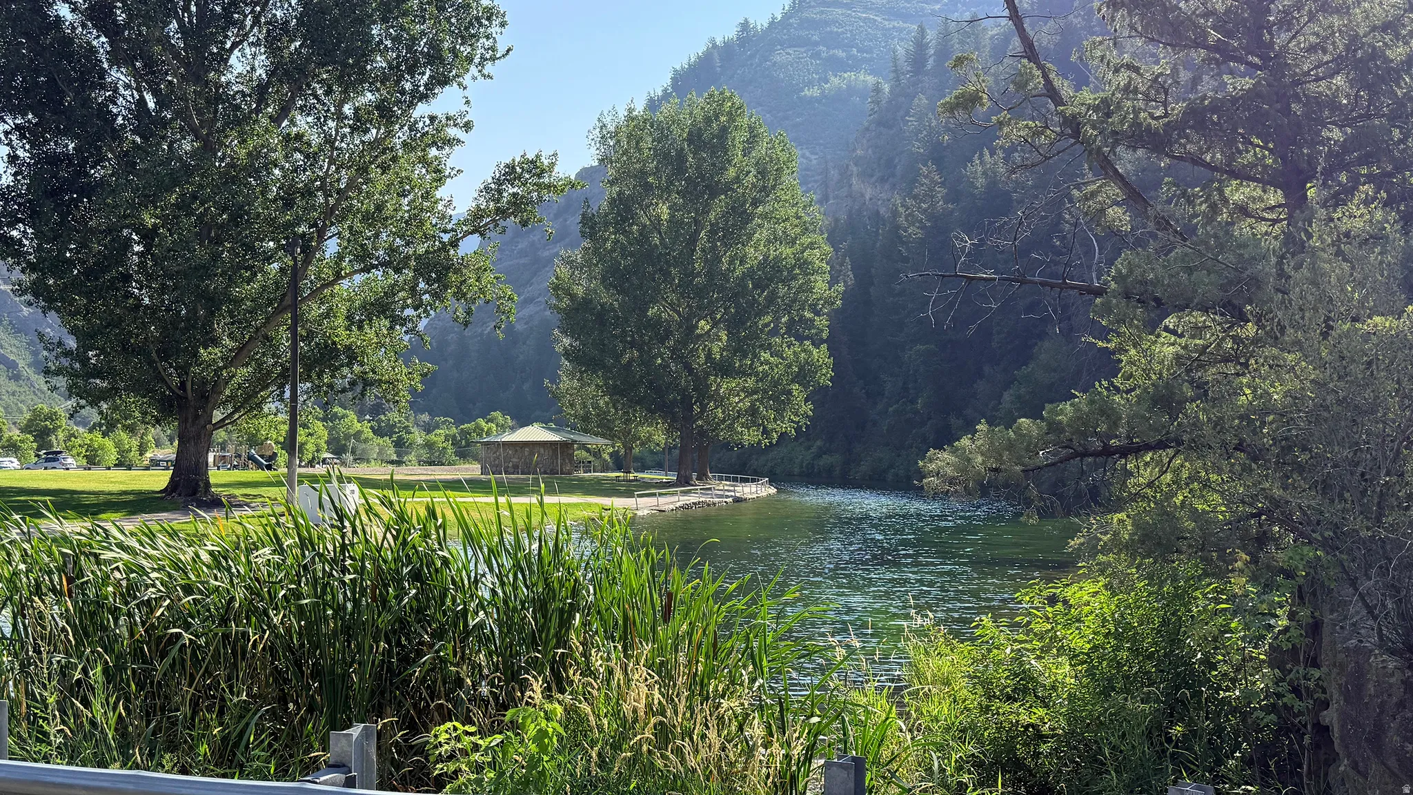 Lakeside setting with mature trees and mountain backdrop