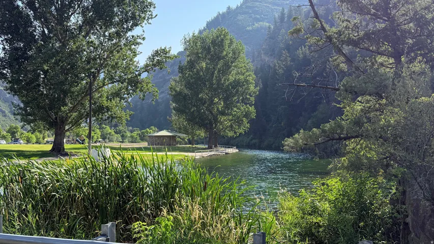 Lakeside setting with mature trees and mountain backdrop