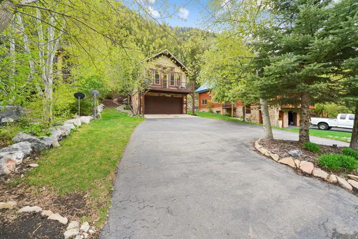 Paved driveway leading to a two-story residence with an integrated garage