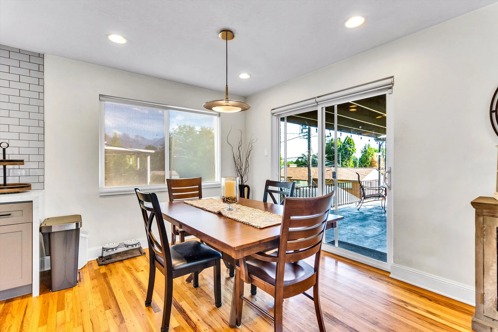 Open-concept dining area featuring wood-finish flooring, recessed lighting, and a modern pendant light