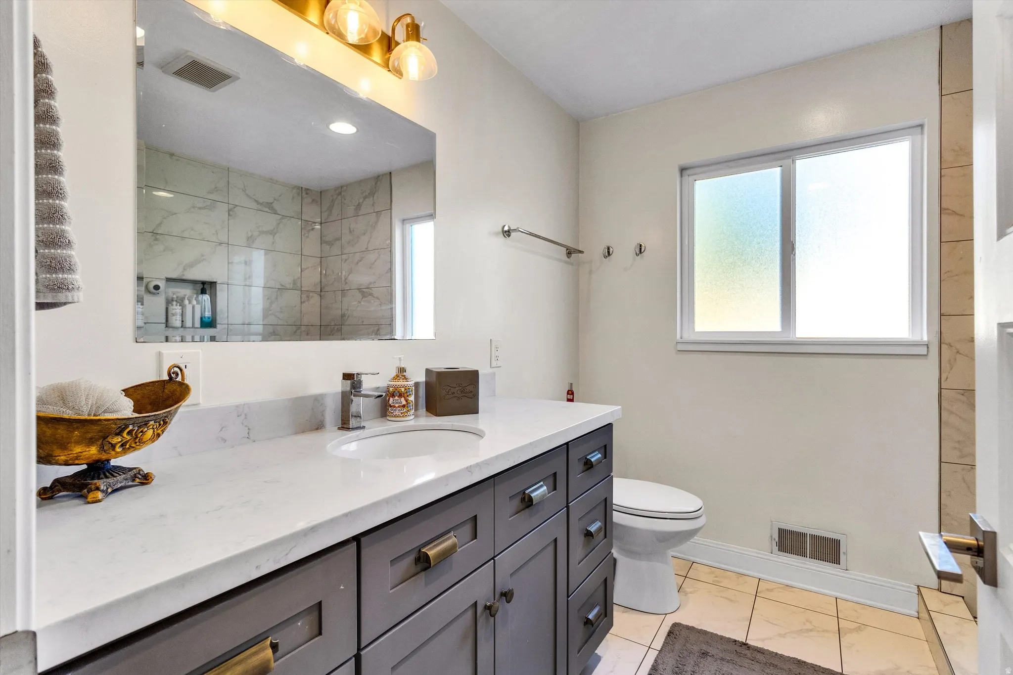 Bathroom featuring a vanity with a white countertop and a single basin sink