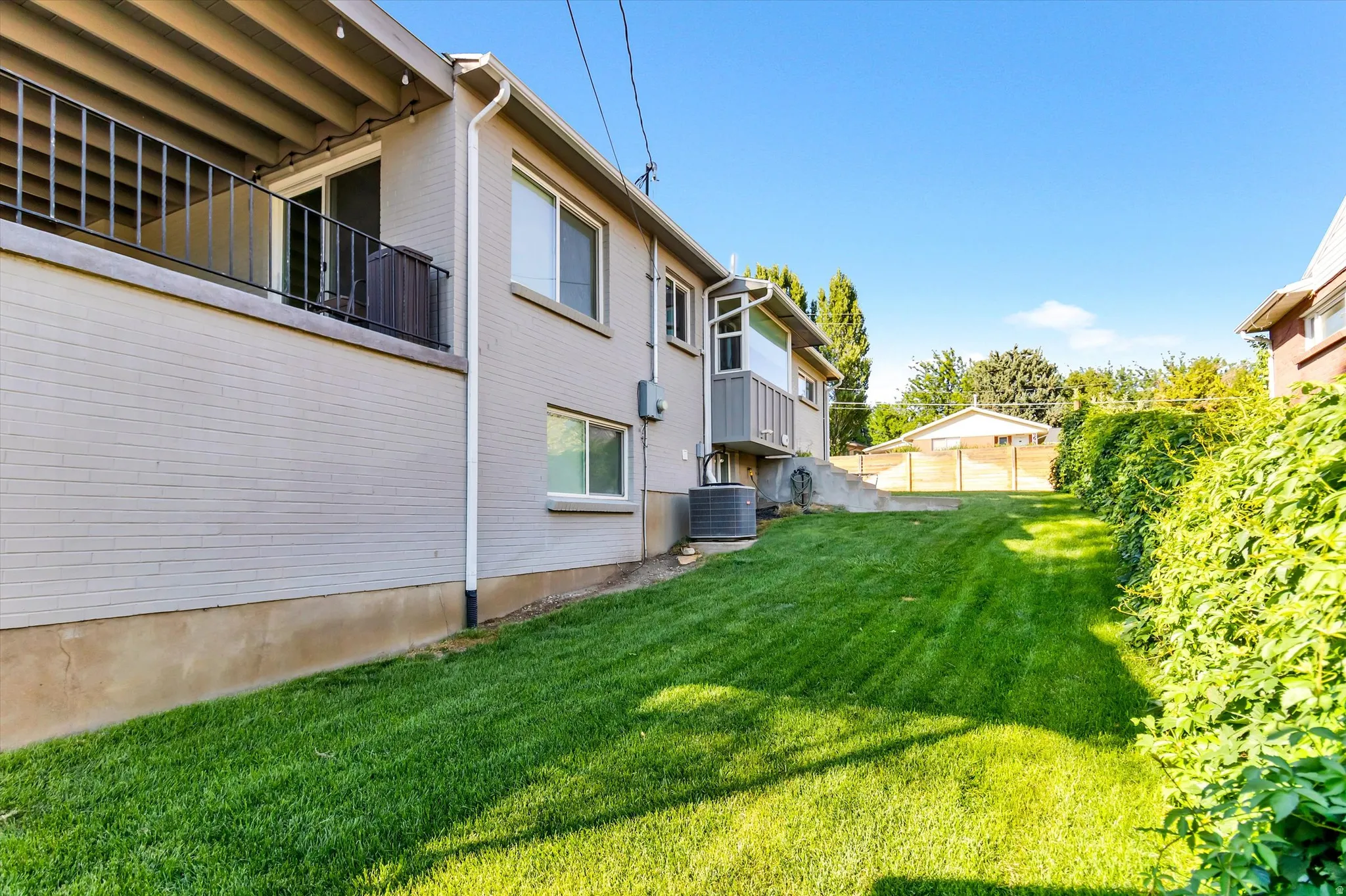 Expansive green lawn bordering a mature hedge