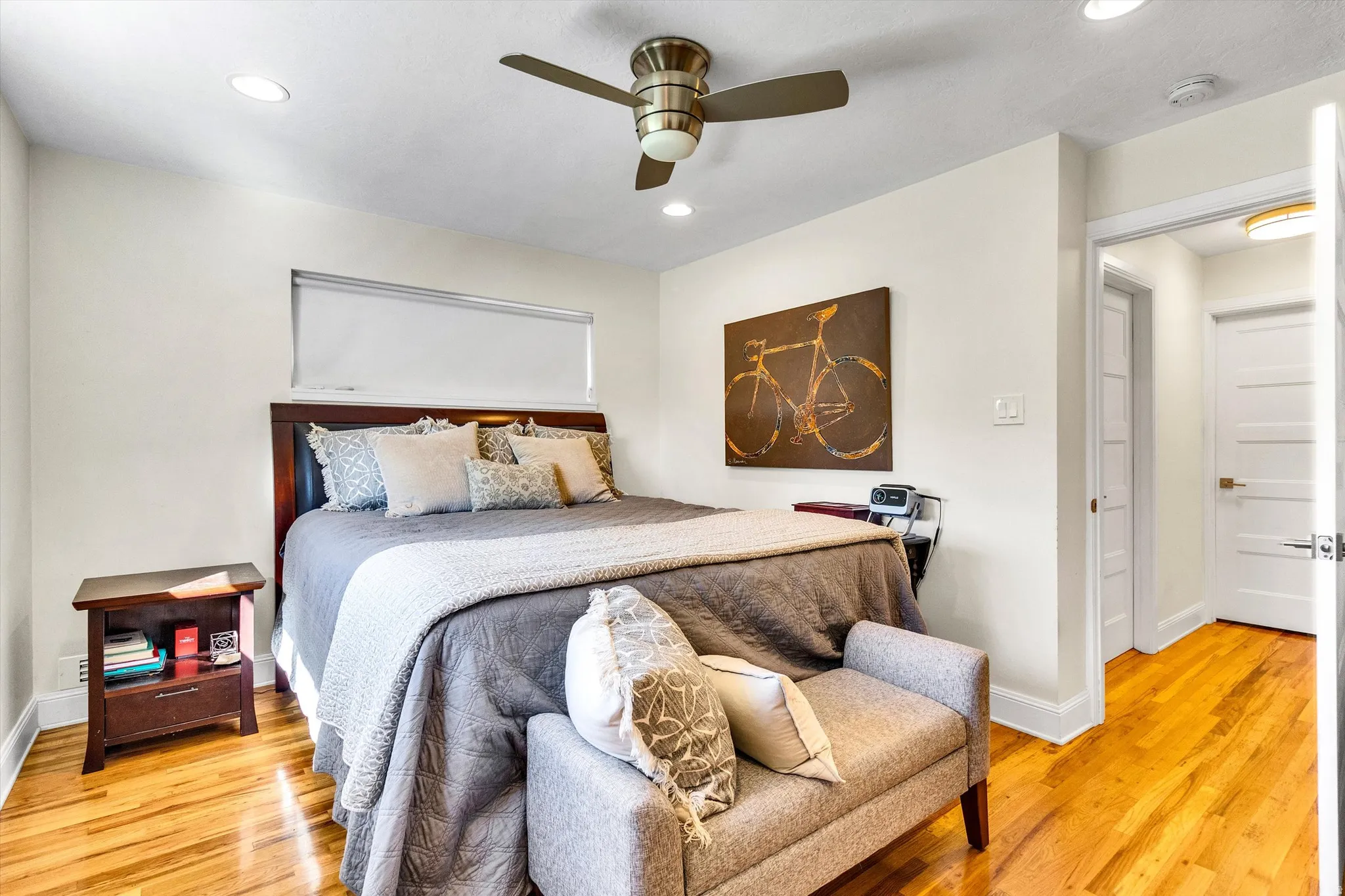 Bedroom featuring hardwood flooring, recessed lighting, a ceiling fan, a horizontal window, and a paneled interior door