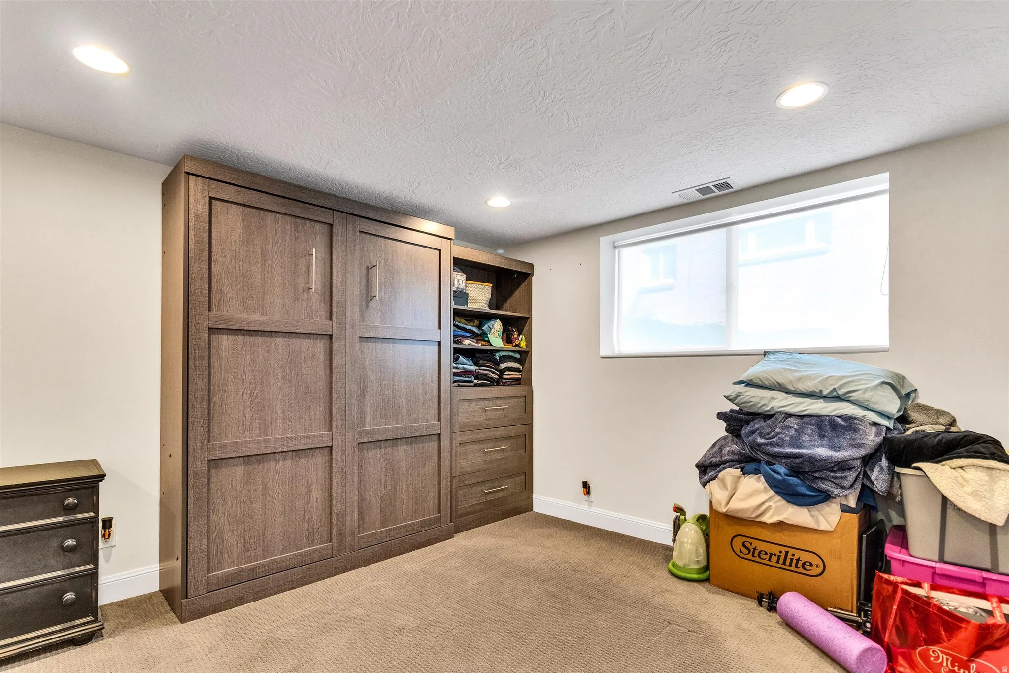 Built-in wood-finish wall bed with integrated cabinetry and shelving