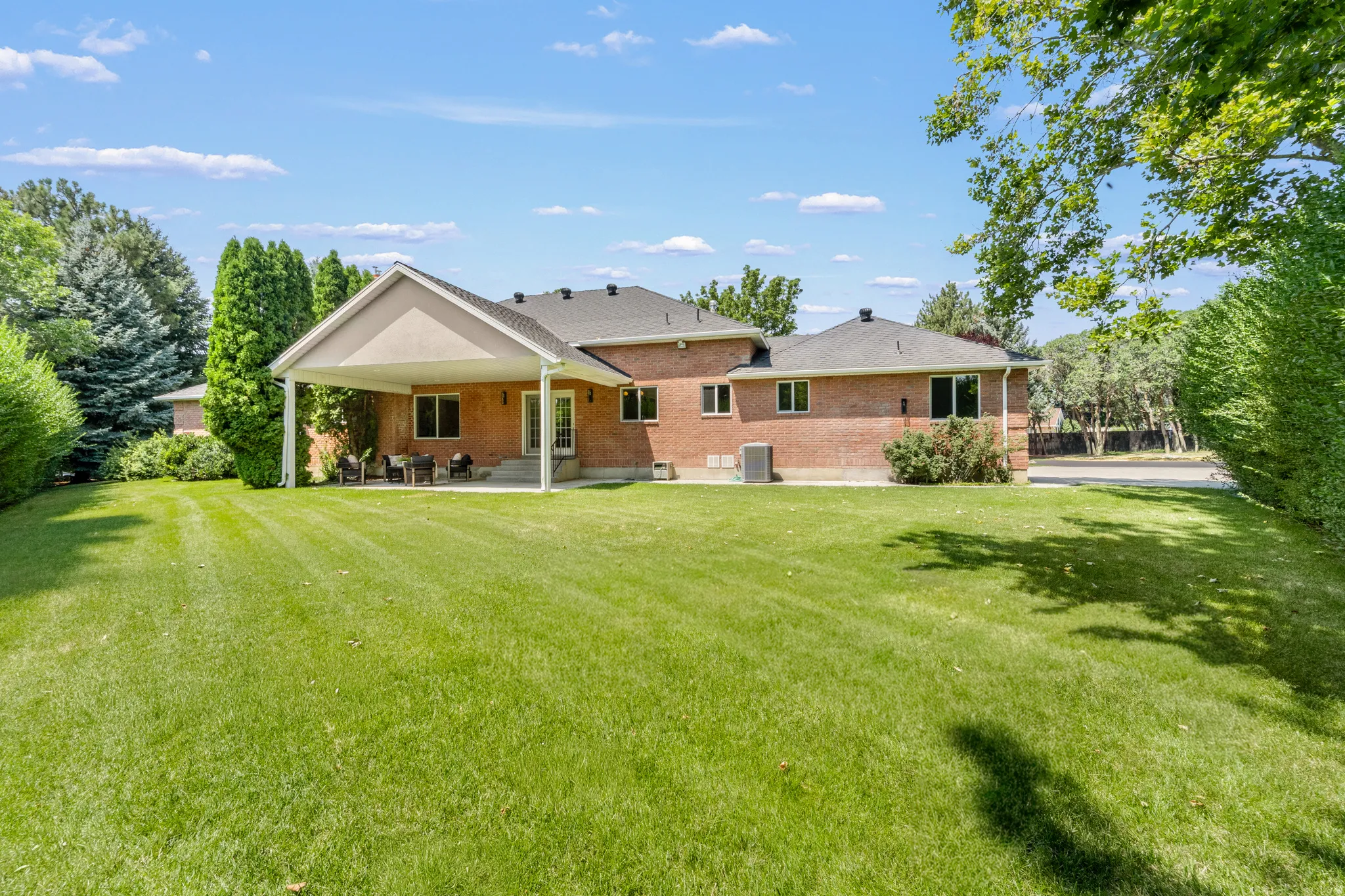Expansive green lawn with mature perimeter landscaping