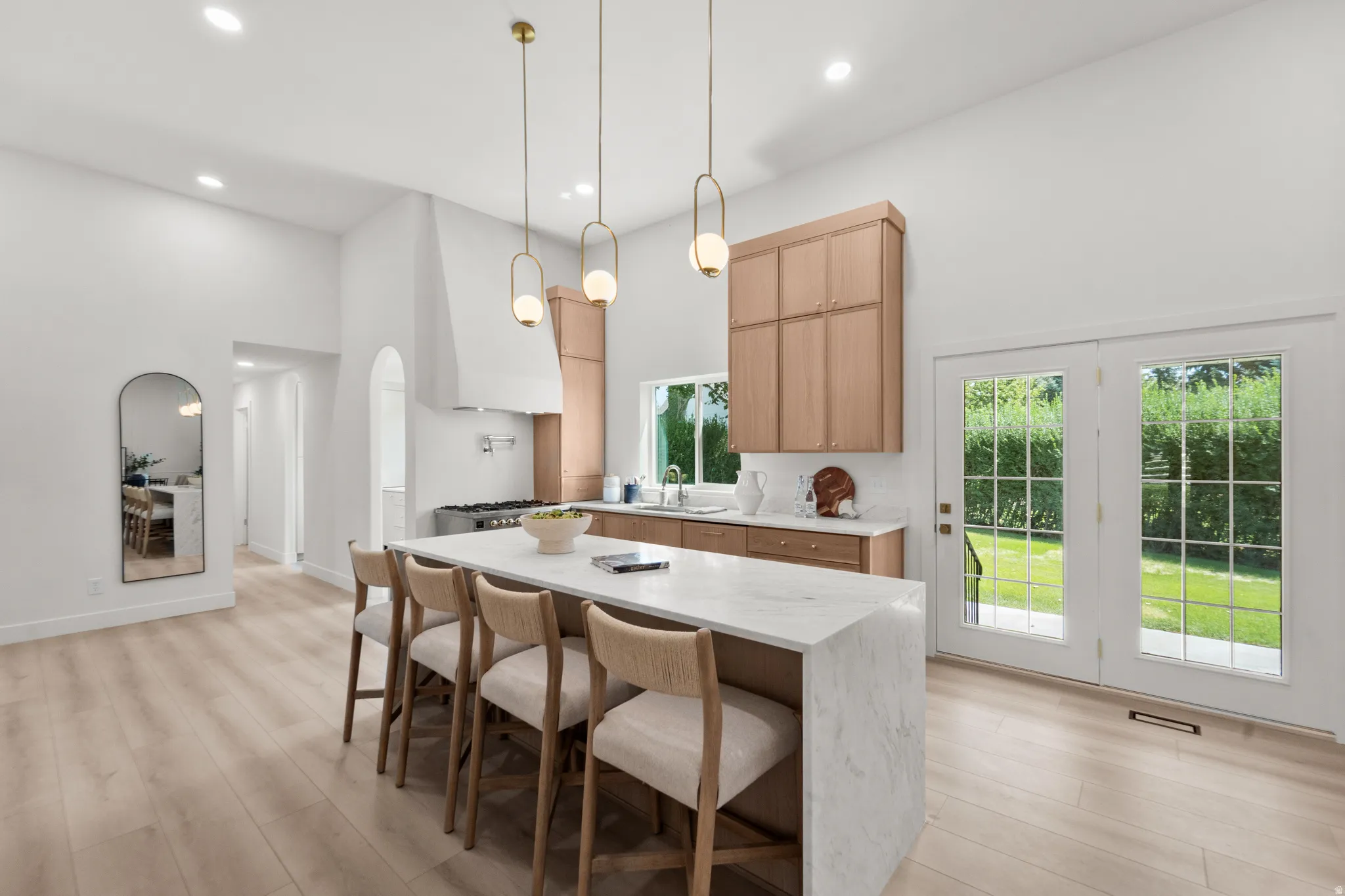Vaulted ceilings, wood-finish flooring, and a kitchen island with seating