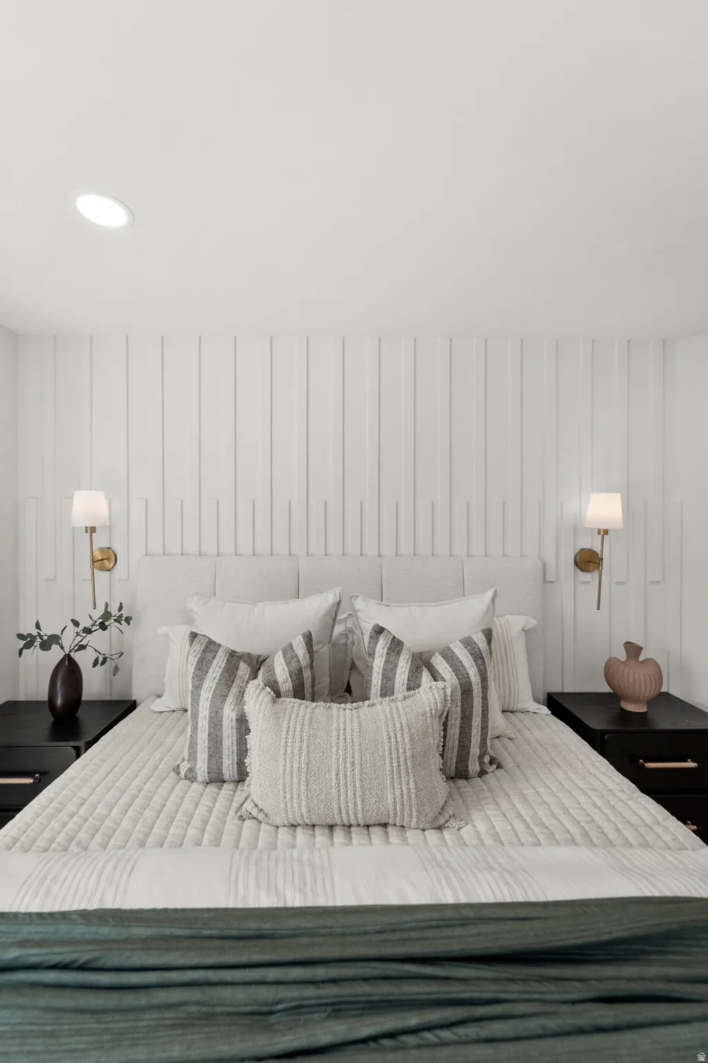 Recessed ceiling lighting illuminates a vertical slat accent wall