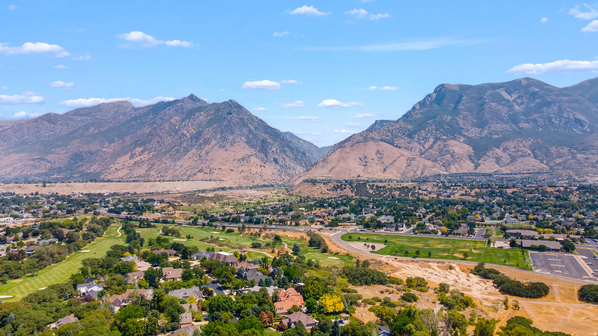 Mountainous terrain surrounds the community, featuring mature trees and a golf course