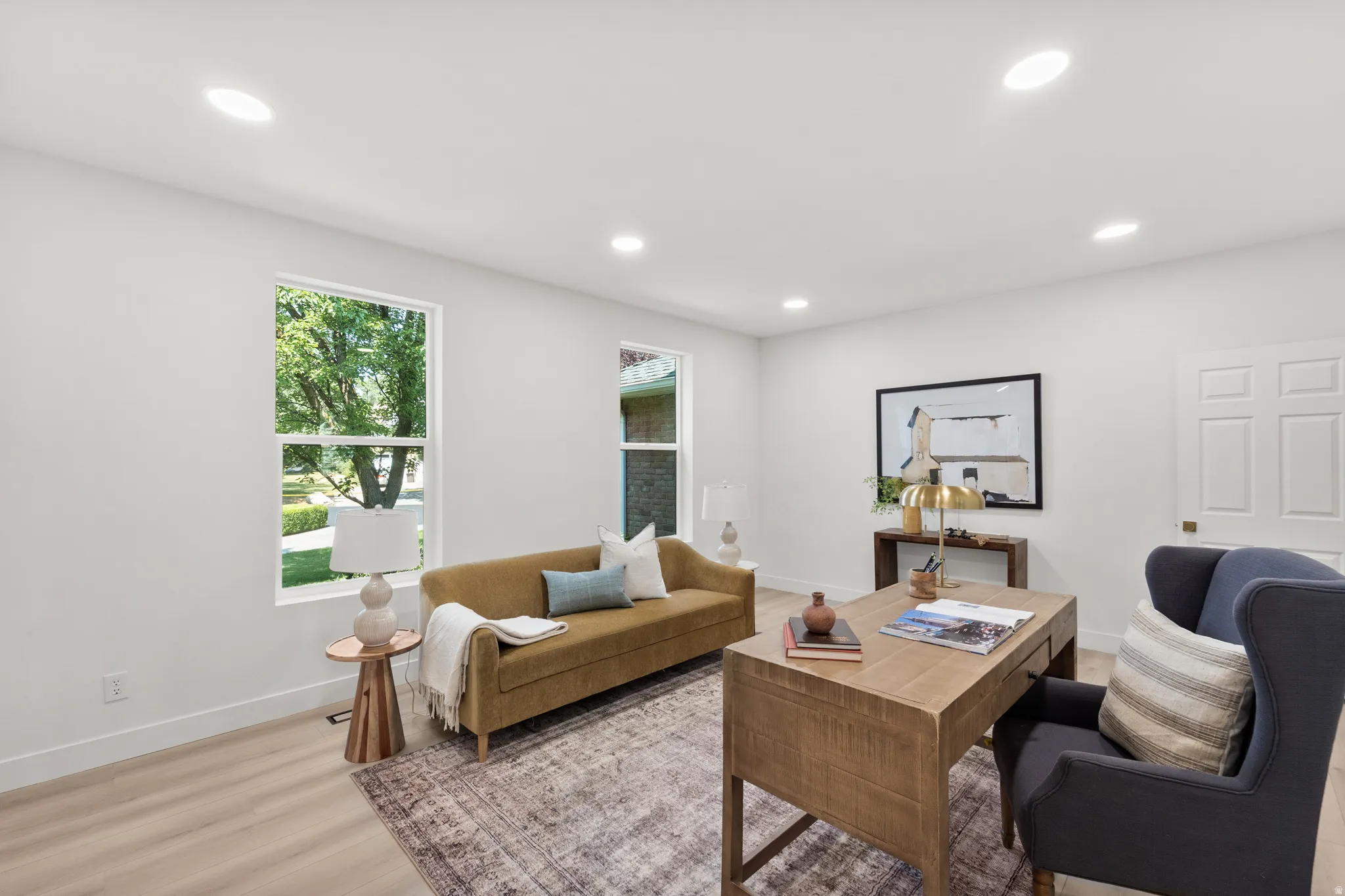 Recessed ceiling lighting, light wood-finish flooring, white walls, and a paneled interior door