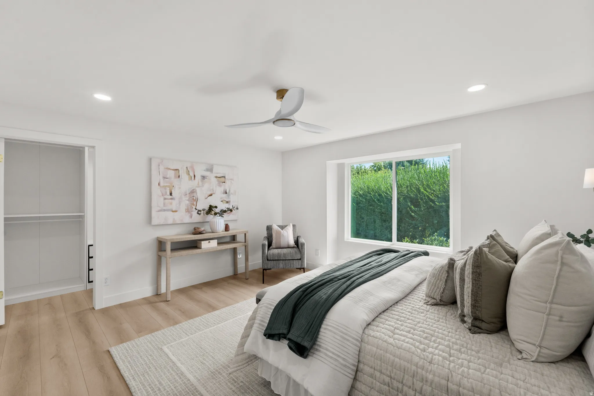 Recessed lighting, wood-finish flooring, ceiling fan, sliding closet doors, and a large window